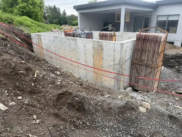 Mur de fondation coulé le long d'une résidence existante